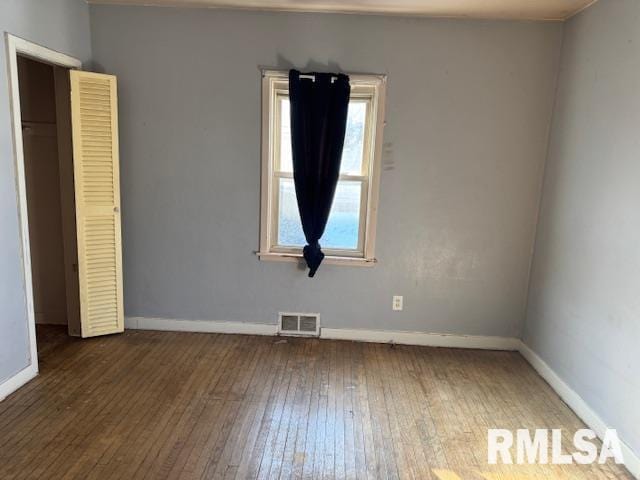 1615 Iowa Ave, Clinton, IA 52732 - unfurnished bedroom with wood-type flooring and baseboards
