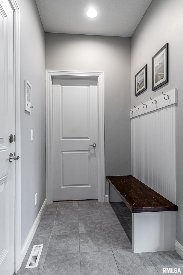 mudroom with dark tile patterned flooring