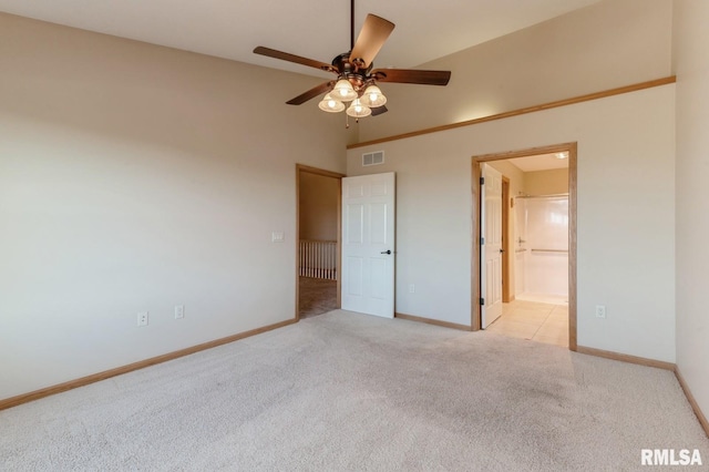 unfurnished bedroom featuring ensuite bathroom, light carpet, and ceiling fan