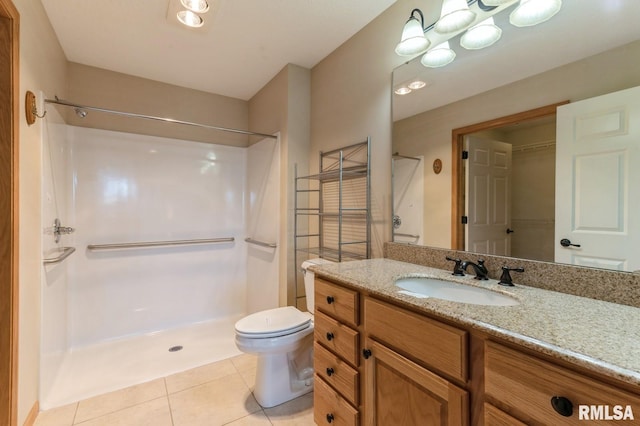 bathroom with vanity, tile patterned floors, toilet, and walk in shower