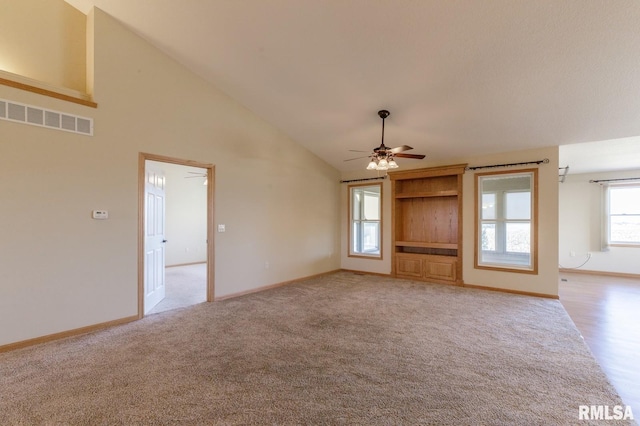 unfurnished living room with ceiling fan, light carpet, and high vaulted ceiling