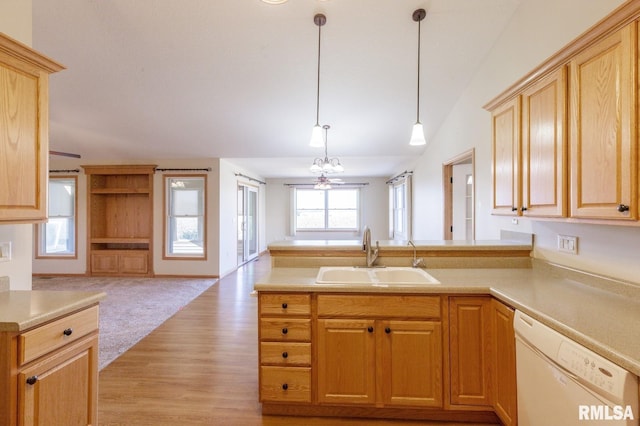 kitchen with light brown cabinetry, sink, hanging light fixtures, light wood-type flooring, and white dishwasher