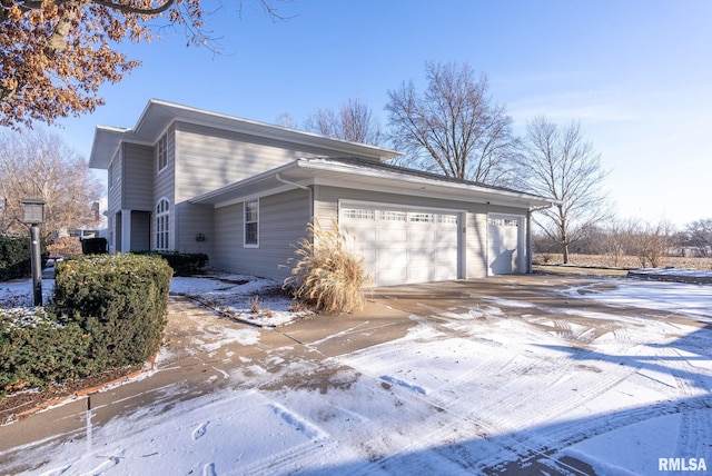 snow covered property with a garage