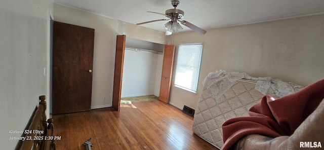 bedroom featuring light wood-type flooring, ceiling fan, and a closet