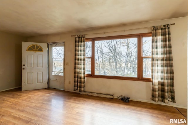 entrance foyer with a baseboard radiator and light wood-type flooring