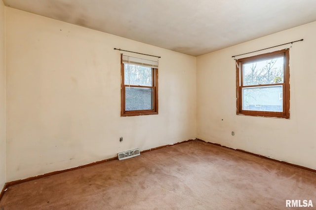 carpeted spare room featuring plenty of natural light