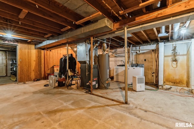 basement featuring water heater, washing machine and dryer, and heating unit