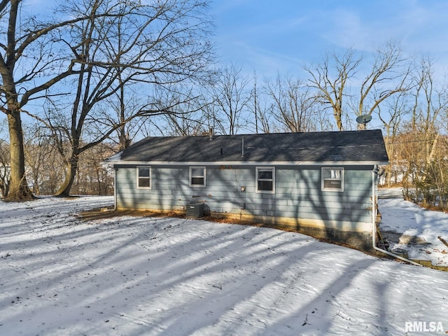 snow covered property with central AC