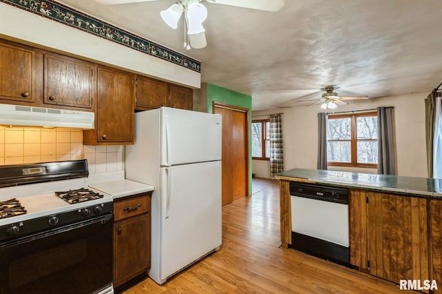 kitchen featuring ceiling fan, white appliances, light hardwood / wood-style flooring, and backsplash