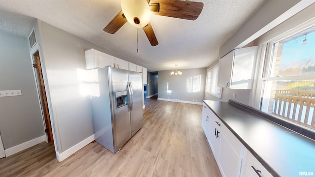 kitchen featuring light hardwood / wood-style flooring, white cabinetry, stainless steel refrigerator with ice dispenser, a textured ceiling, and decorative light fixtures