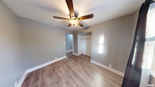 unfurnished bedroom featuring light hardwood / wood-style floors, a closet, and ceiling fan