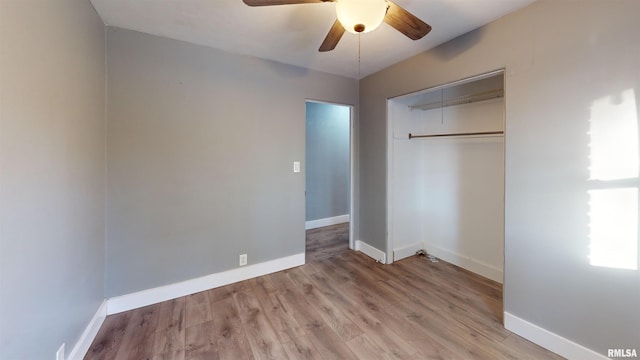 unfurnished bedroom featuring ceiling fan, a closet, and light wood-type flooring