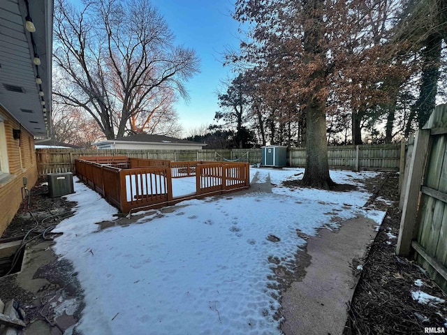 yard layered in snow featuring central AC unit