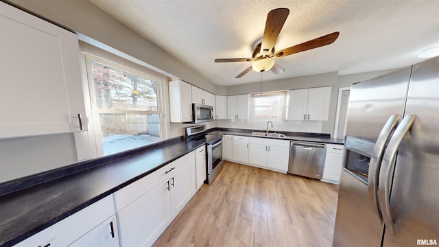 kitchen featuring plenty of natural light, appliances with stainless steel finishes, sink, and white cabinets