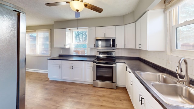 kitchen featuring white cabinetry, appliances with stainless steel finishes, sink, and a wealth of natural light