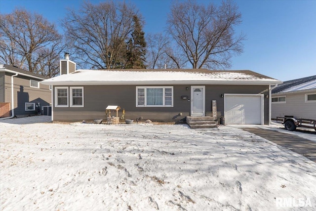 ranch-style home featuring cooling unit and a garage