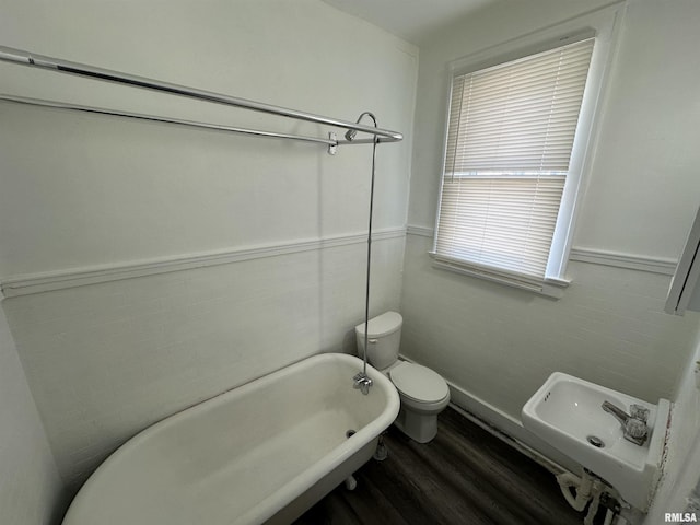 bathroom with hardwood / wood-style floors, a bathtub, sink, and toilet