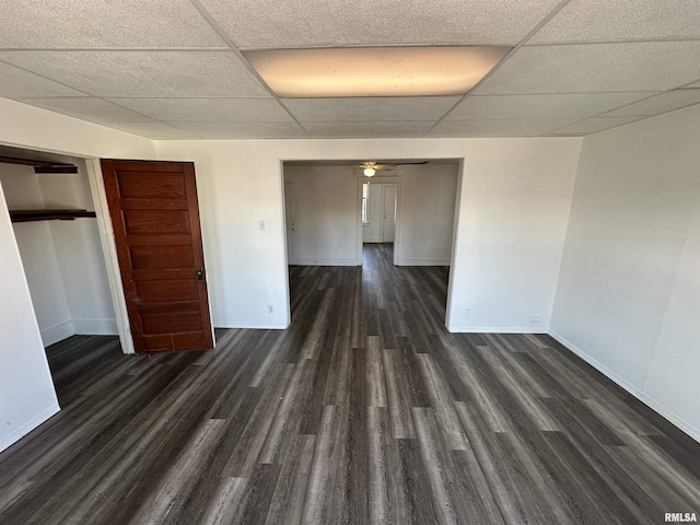 empty room with ceiling fan, a paneled ceiling, and dark hardwood / wood-style floors