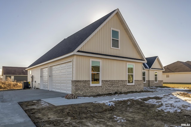 view of side of property featuring a garage and central air condition unit