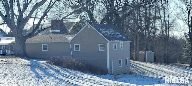 view of snow covered exterior featuring a shed