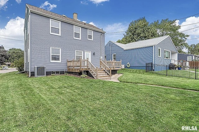 rear view of house featuring a wooden deck, a yard, and central AC