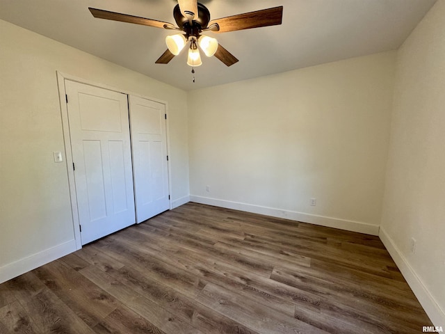 unfurnished bedroom featuring ceiling fan, dark hardwood / wood-style flooring, and a closet