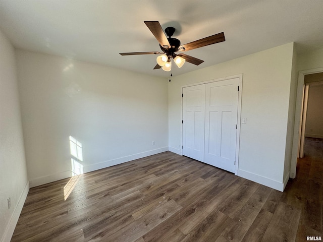 unfurnished bedroom with ceiling fan, dark hardwood / wood-style floors, and a closet