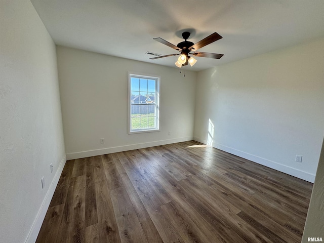 empty room featuring dark wood-type flooring and ceiling fan