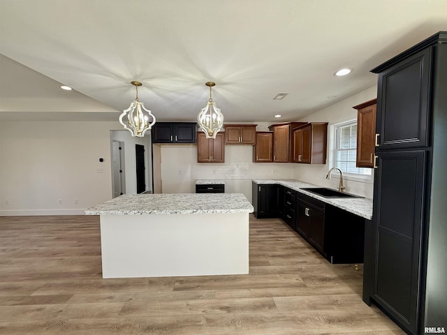 kitchen with light hardwood / wood-style floors, a center island, sink, and backsplash