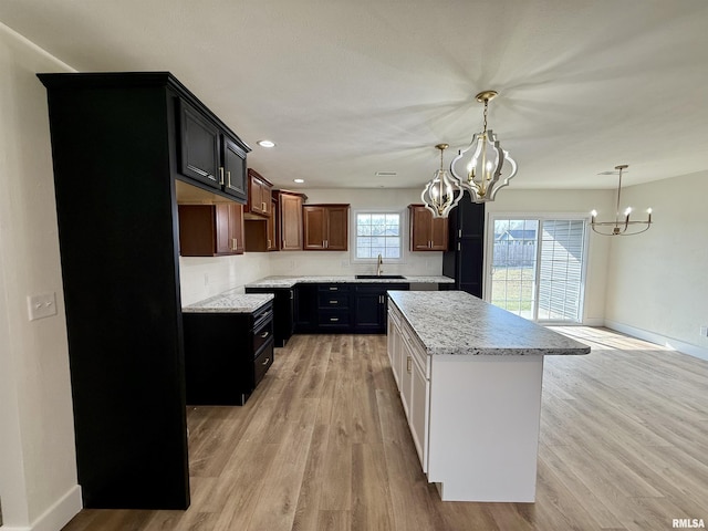 kitchen featuring sink, plenty of natural light, a center island, and light wood-type flooring