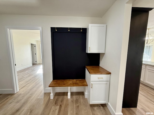 mudroom with an inviting chandelier and light wood-type flooring