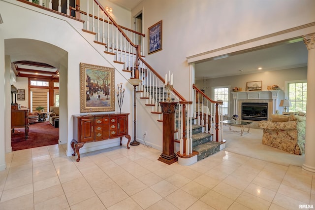 stairway featuring tile patterned flooring, a wealth of natural light, and decorative columns