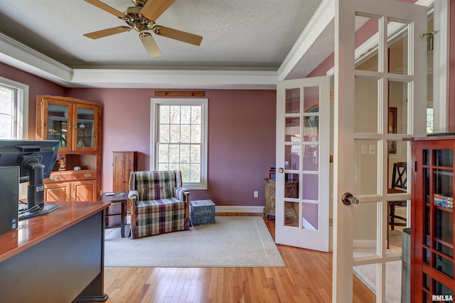 home office featuring french doors, a textured ceiling, ornamental molding, ceiling fan, and light hardwood / wood-style floors