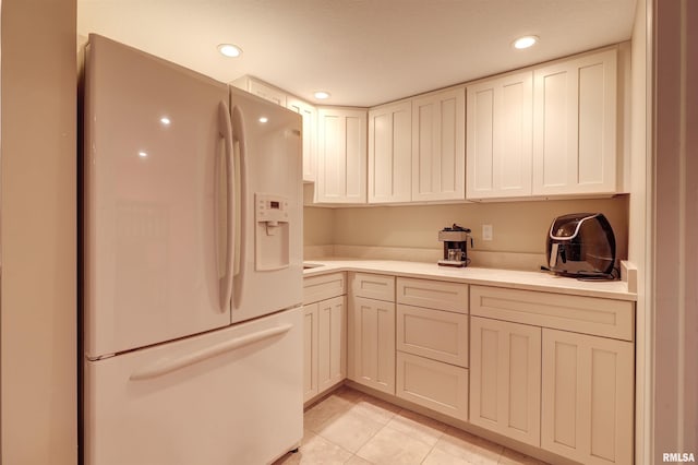 kitchen featuring light tile patterned floors and white fridge with ice dispenser