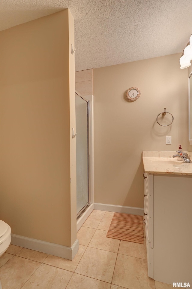 bathroom with tile patterned flooring, vanity, a shower with door, and a textured ceiling