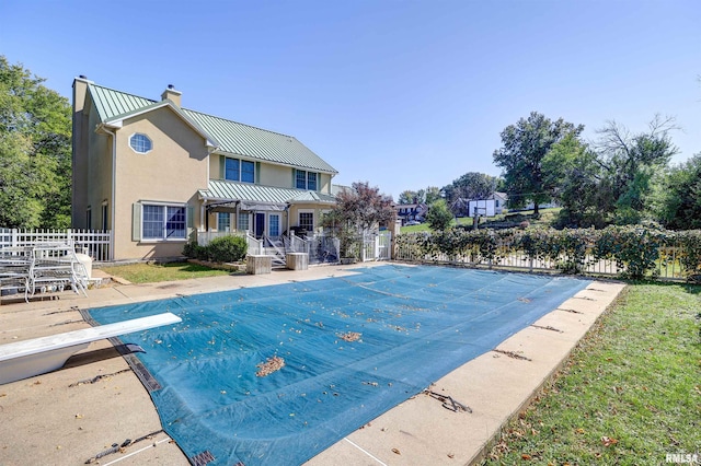 view of pool with a patio and a diving board