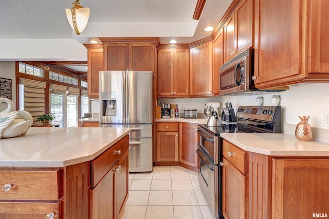 kitchen with light tile patterned flooring, light stone counters, decorative light fixtures, a textured ceiling, and appliances with stainless steel finishes