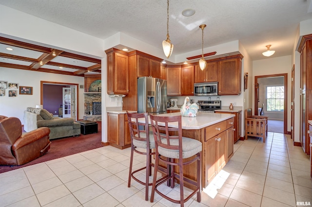 kitchen with a breakfast bar, pendant lighting, beamed ceiling, coffered ceiling, and stainless steel appliances