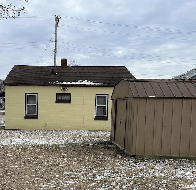 rear view of house with a storage shed