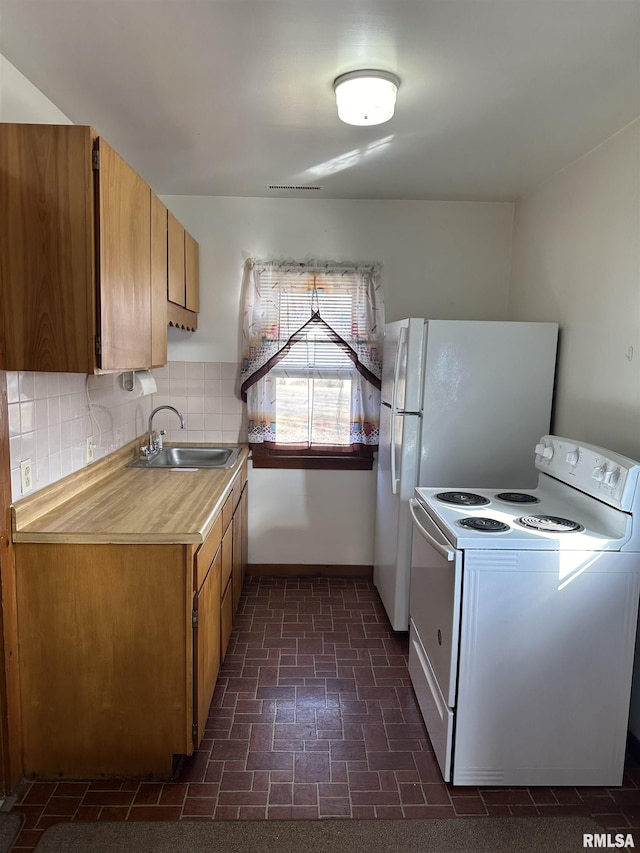 kitchen with sink, electric range, and backsplash