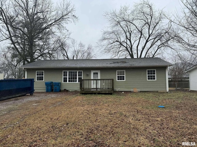 rear view of house with a deck and a lawn