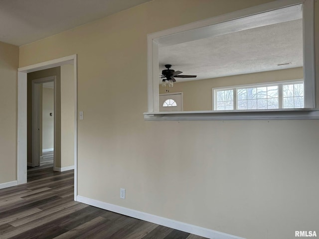 empty room featuring a textured ceiling, dark hardwood / wood-style floors, and ceiling fan