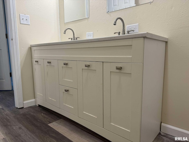 bathroom with baseboards, wood finished floors, and vanity