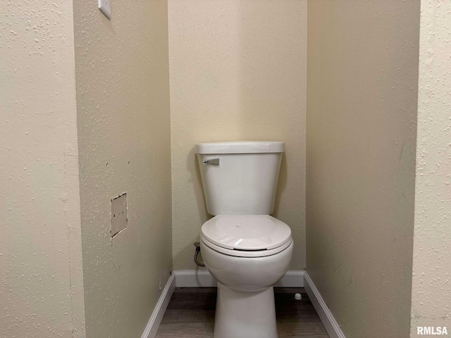 bathroom featuring wood-type flooring and toilet