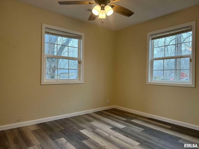 unfurnished room with a ceiling fan, dark wood finished floors, and baseboards