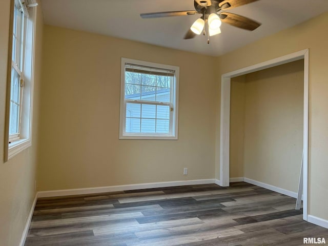 unfurnished bedroom featuring ceiling fan, dark wood finished floors, and baseboards