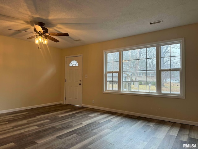 foyer entrance featuring ceiling fan, dark wood-type flooring, and a textured ceiling