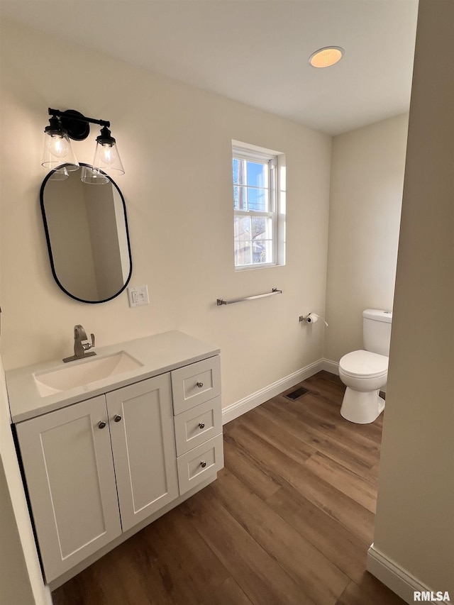 bathroom with hardwood / wood-style flooring, vanity, and toilet