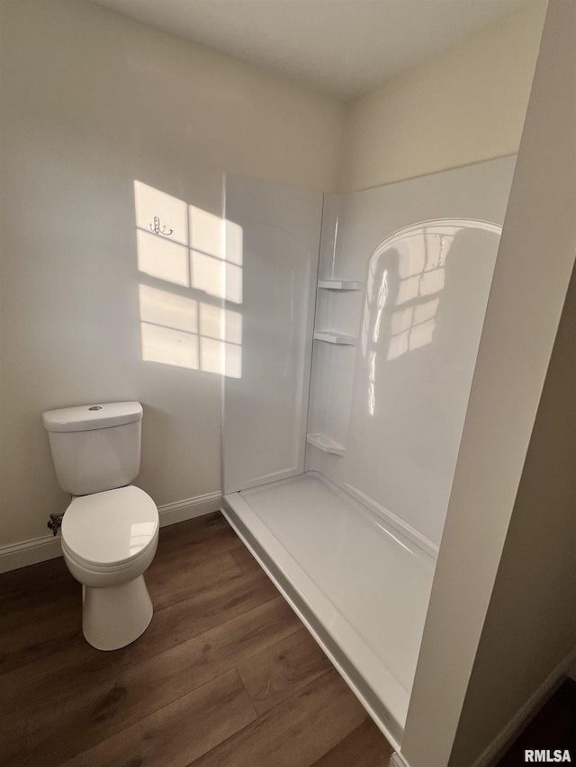 bathroom featuring wood-type flooring, walk in shower, and toilet