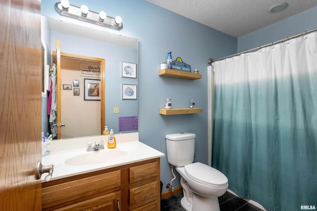 bathroom featuring vanity, toilet, and a textured ceiling